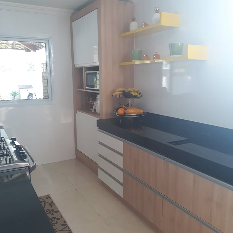 Cozinha com nichos amarelos e madeira clara — projeto Castro